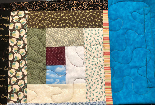 Front of placemat features colorful log cabin quilt block joined to a bright blue border.